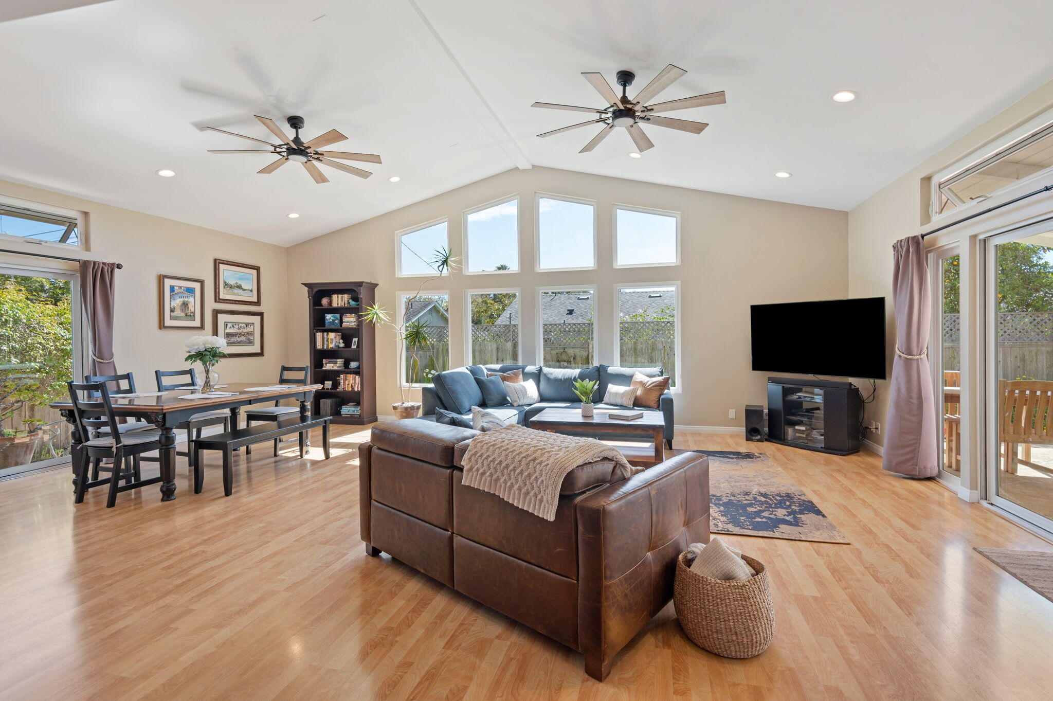 a living room with furniture ceiling fan and a flat screen tv