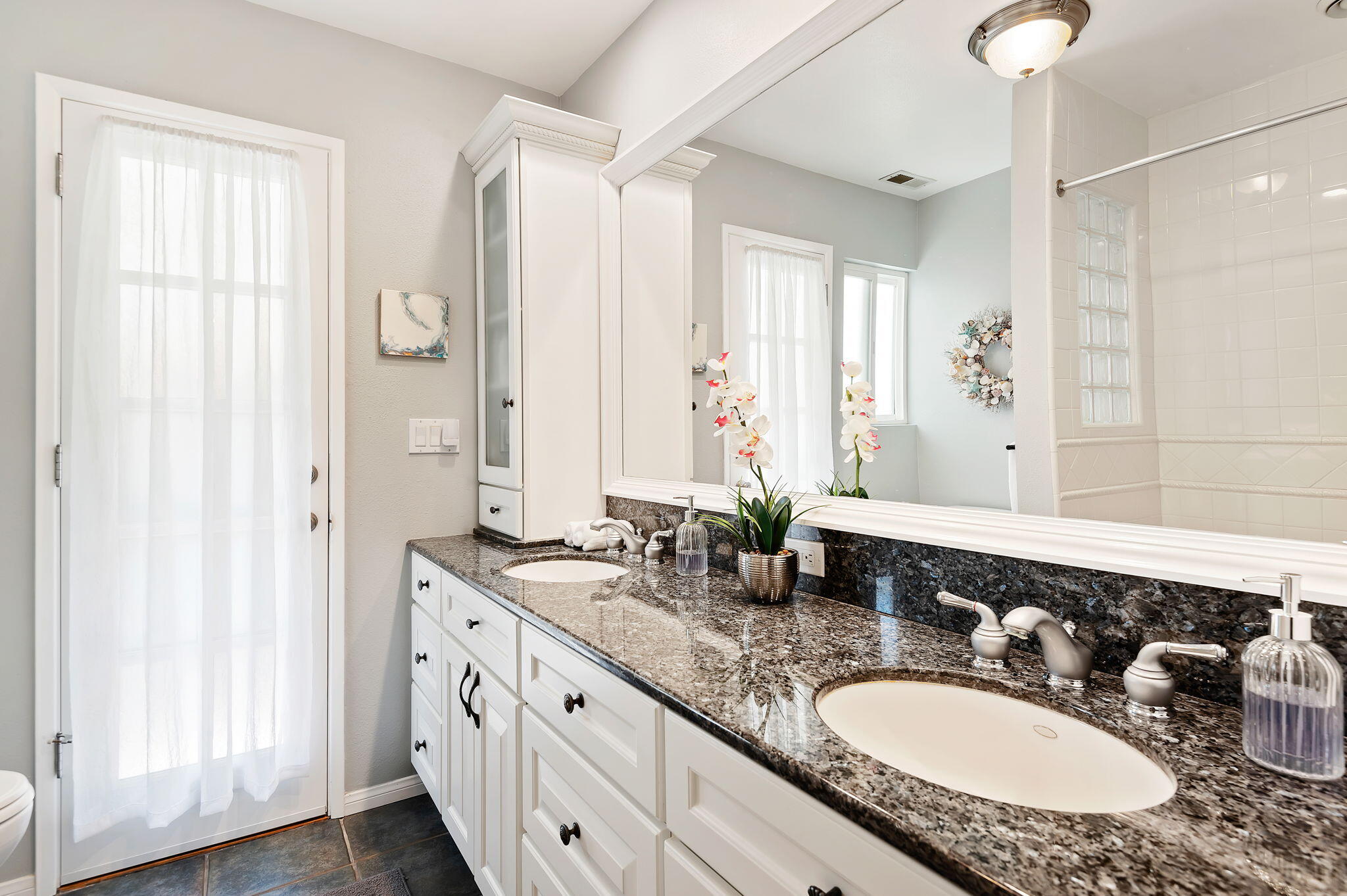 7635 Anchor Drive Goleta, CA 93117 - Photo 12 of 24 a bathroom with a granite countertop double vanity sink and a mirror