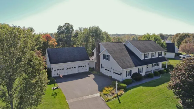a view of a house with a big yard plants and large trees