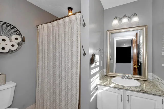 a bathroom with a granite countertop sink and a mirror