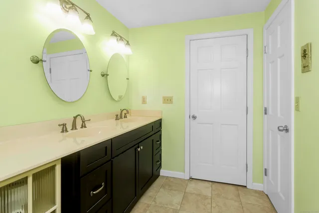 a bathroom with a double vanity sink and a mirror