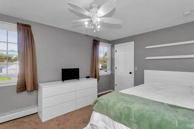 a bedroom with a bed and a large window