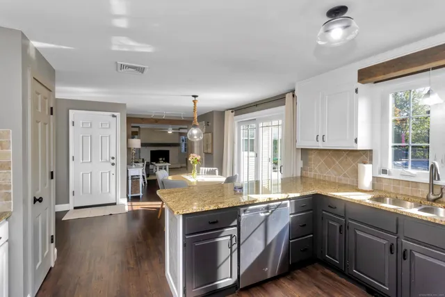 a kitchen with granite countertop a sink cabinets and wooden floor