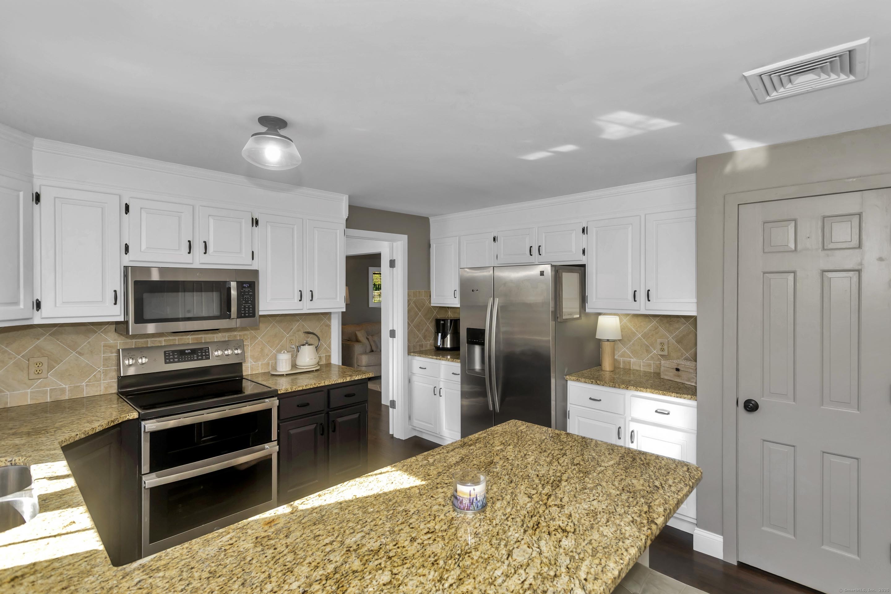 57 Kildeer Lane Suffield, CT 06078 - Photo 7 of 37 a kitchen with stainless steel appliances kitchen island granite countertop a refrigerator and a stove top oven