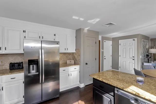 a kitchen with granite countertop a refrigerator and stove