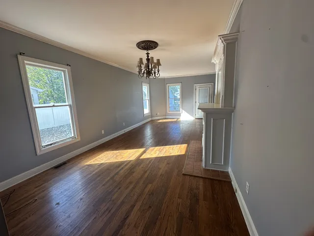 a view of a room with wooden floor staircase and a living room