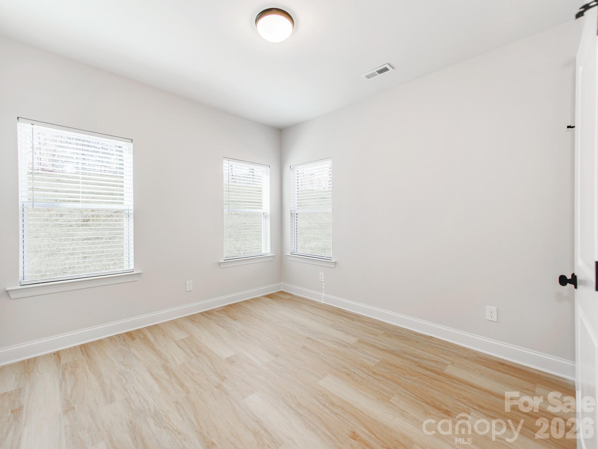 176 Whitetail Road Statesville, NC 28625 - Photo 17 of 23 an empty room with wooden floor and windows