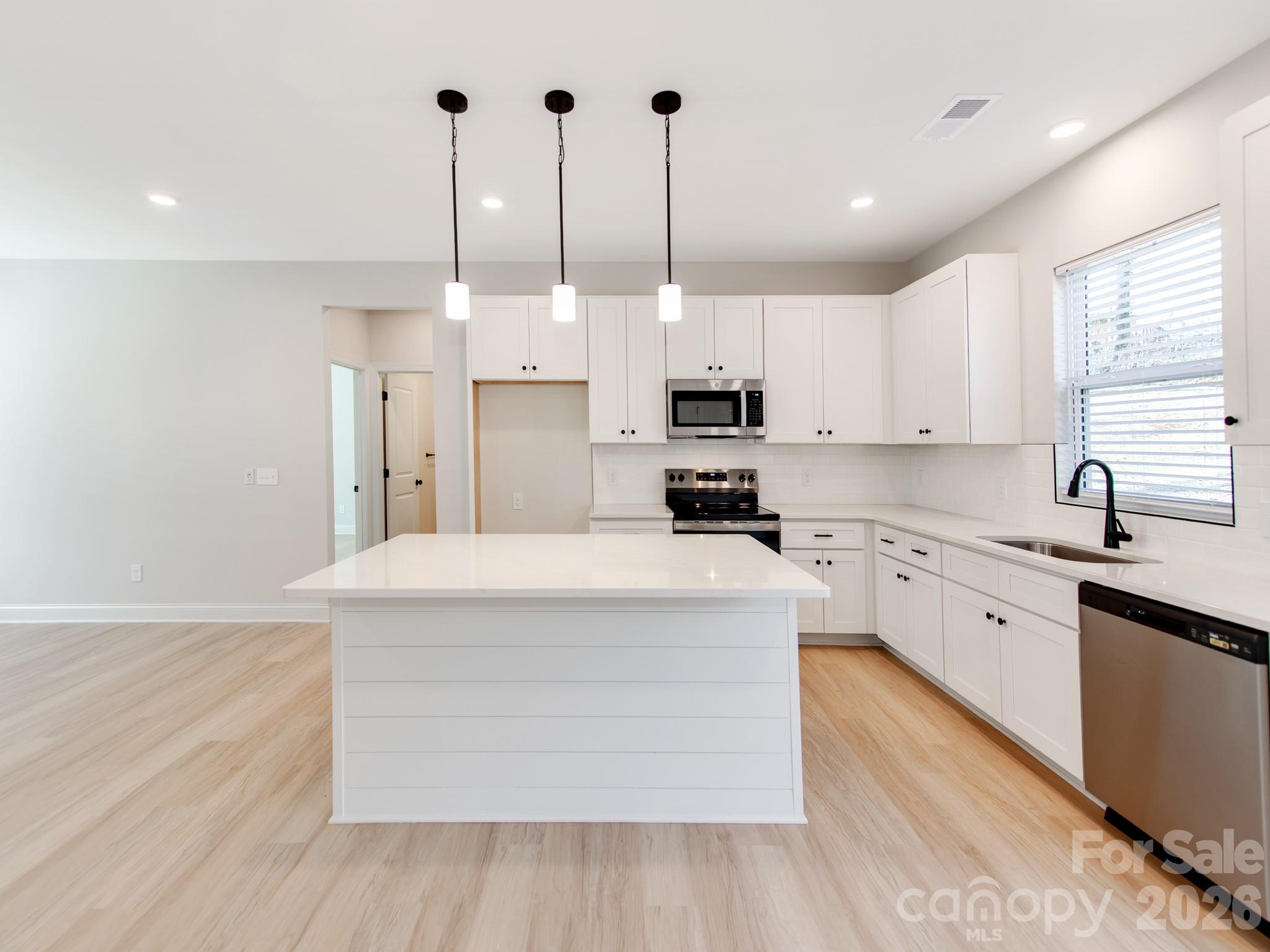 176 Whitetail Road Statesville, NC 28625 - Photo 8 of 23 a large kitchen with stainless steel appliances kitchen island granite countertop a sink a stove and a wooden floors