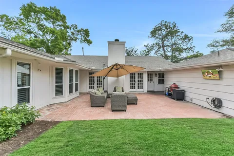 a view of a house with backyard and sitting area