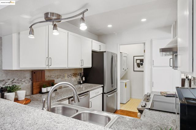 a kitchen with stainless steel appliances granite countertop a refrigerator and a sink