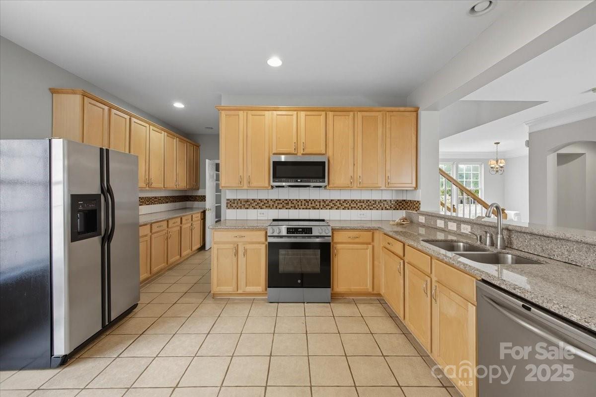 17005 Carlton Way Road Huntersville, NC 28078 - Photo 15 of 45 a kitchen with stainless steel appliances granite countertop a stove top oven a sink and a refrigerator