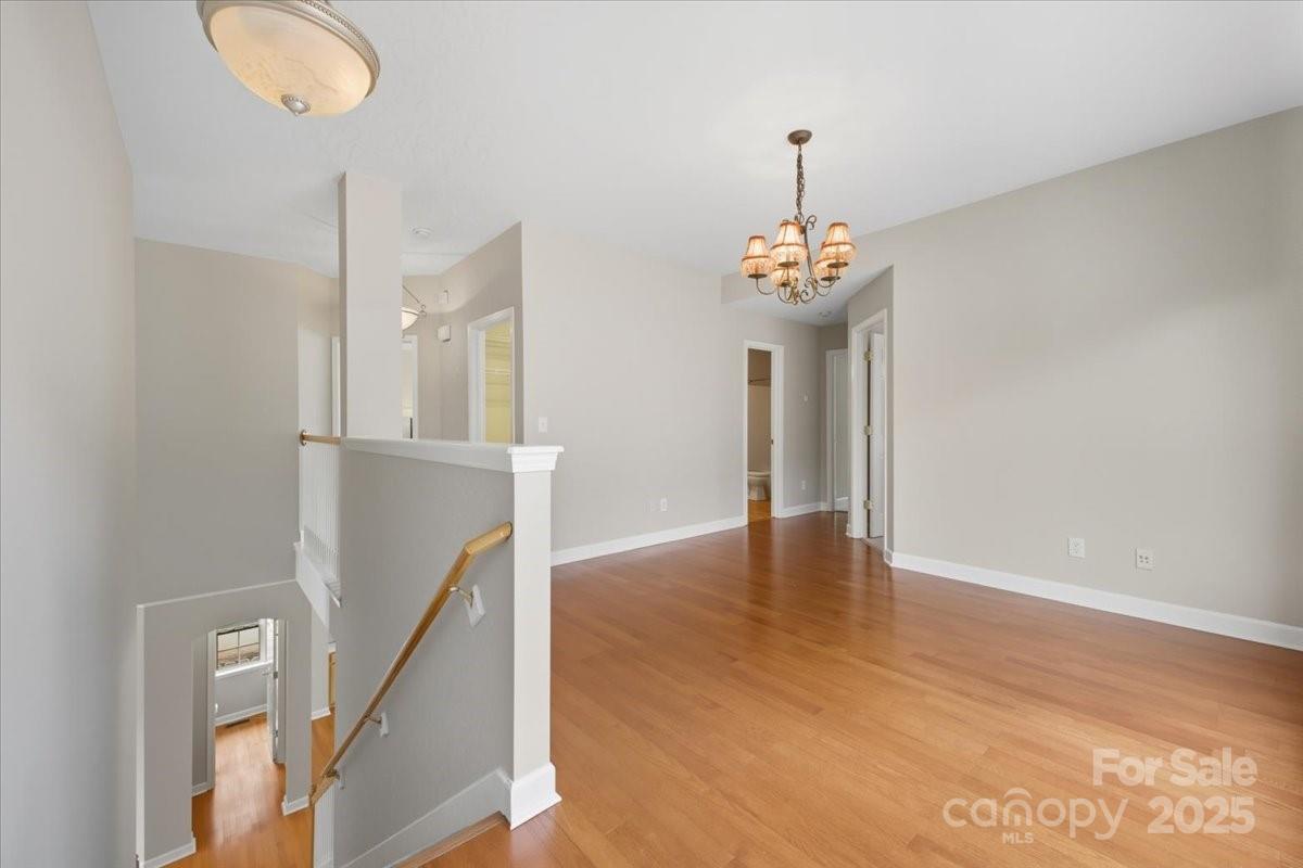 17005 Carlton Way Road Huntersville, NC 28078 - Photo 18 of 45 a view of a hallway with wooden floor and a chandelier
