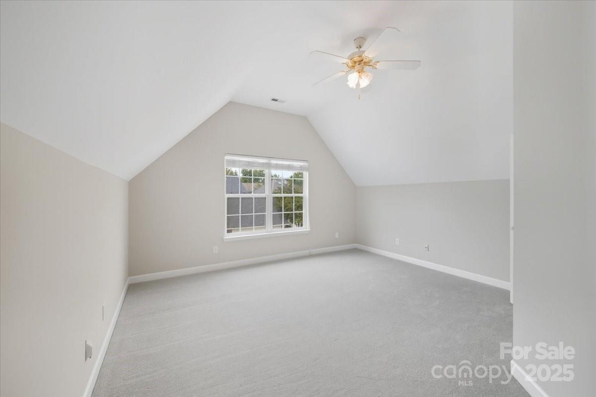 17005 Carlton Way Road Huntersville, NC 28078 - Photo 25 of 45 an empty room with a chandelier fan and windows