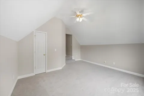 a view of an empty room with a chandelier fan