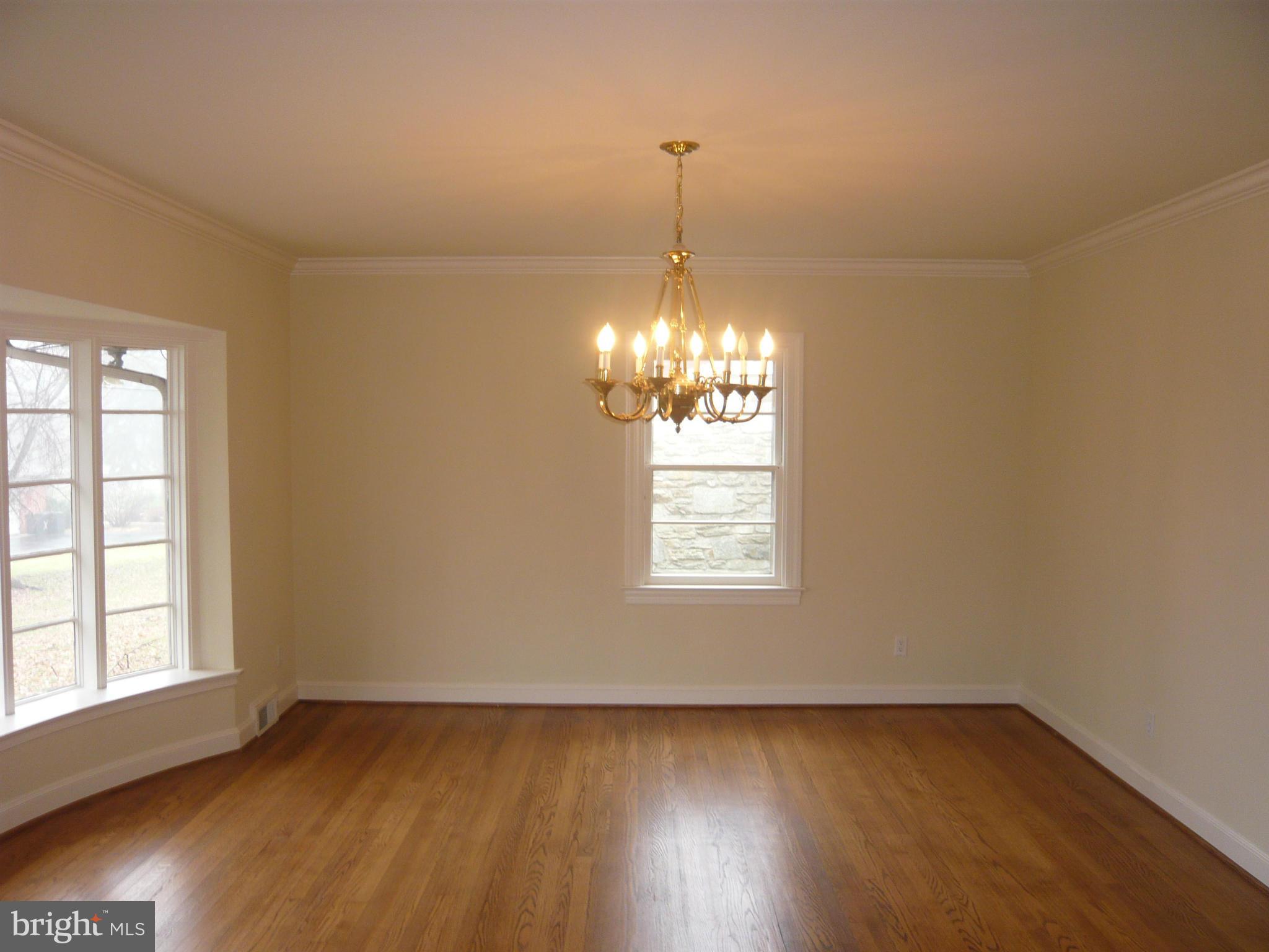 725 Milldam Road Towson, MD 21286 - Photo 7 of 21 a view of empty room with wooden floor and chandelier