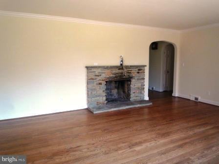 725 Milldam Road Towson, MD 21286 - Photo 9 of 21 a view of empty room with wooden floor and fireplace