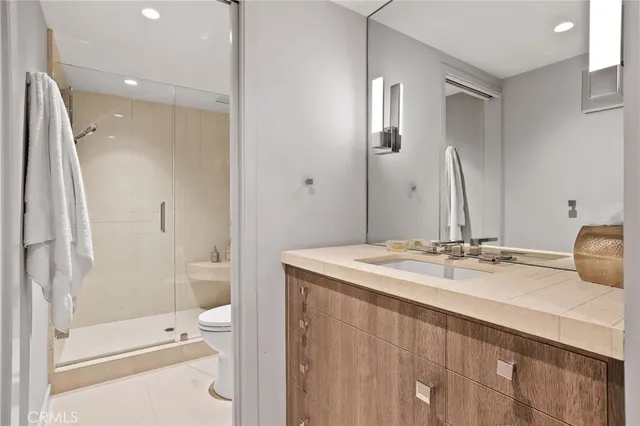 a bathroom with a granite countertop sink toilet and shower