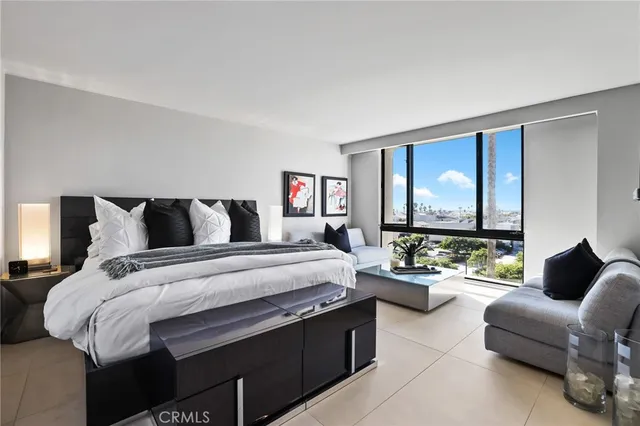 a bedroom with a bed couch and a large window