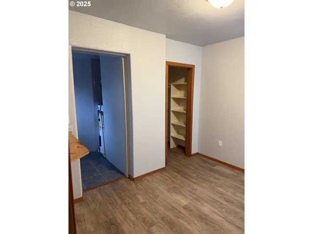 a view of an empty room with closet and a window