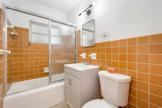 a bathroom with a toilet a sink a mirror and shower