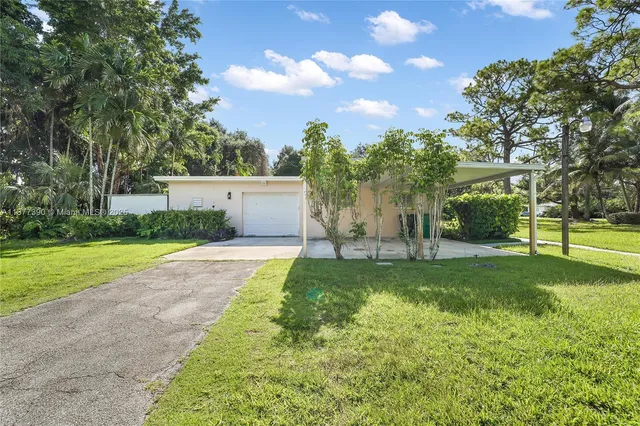a view of a house with a big yard and a large tree