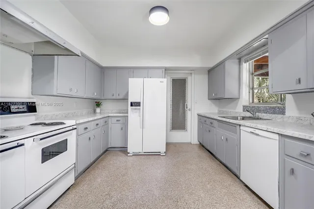 a kitchen with granite countertop cabinets and white appliances