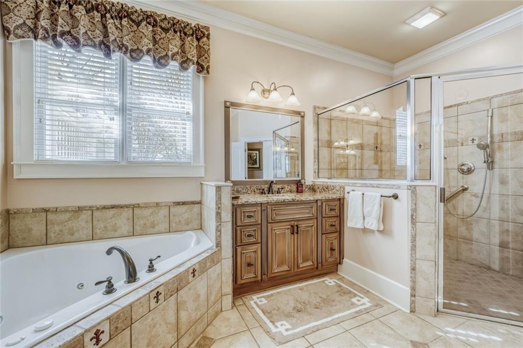 2380 Muskogee Lane Braselton, GA 30517 - Photo 28 of 30 a bathroom with a granite countertop tub sink a mirror a shower and vanity