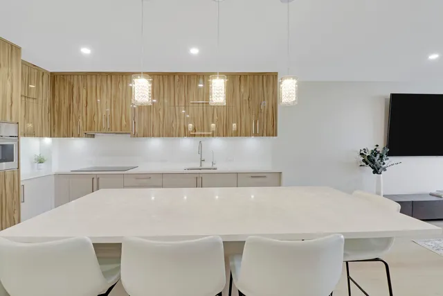 a kitchen with a white cabinets a sink and a potted plant