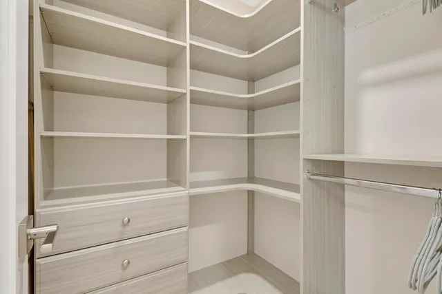 a view of walk in closet with empty racks