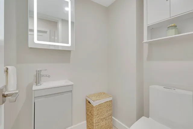 a bathroom with a sink a toilet and a mirror