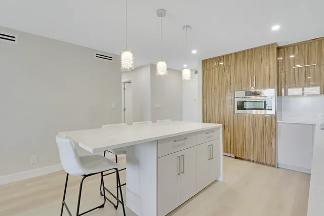a kitchen with a table chairs refrigerator and microwave