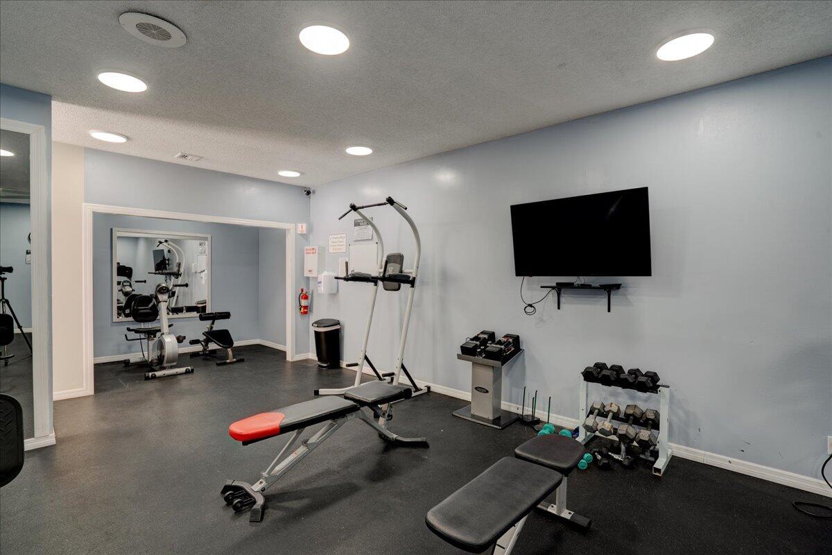 3540 South Ocean Boulevard, Unit 715 South Palm Beach, FL 33480 - Photo 38 of 39 a room with gym equipment and a flat screen tv