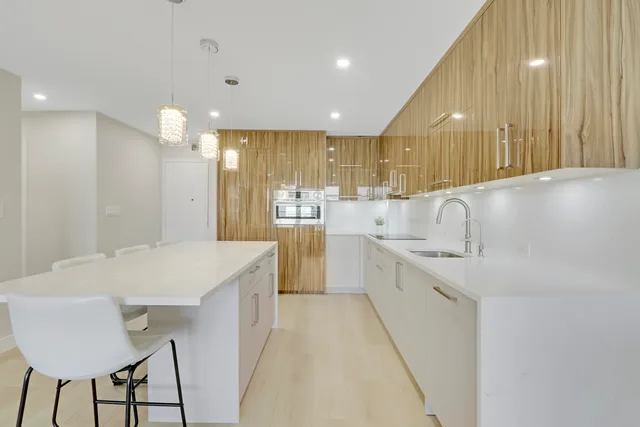 a large kitchen with kitchen island a sink stainless steel appliances and cabinets