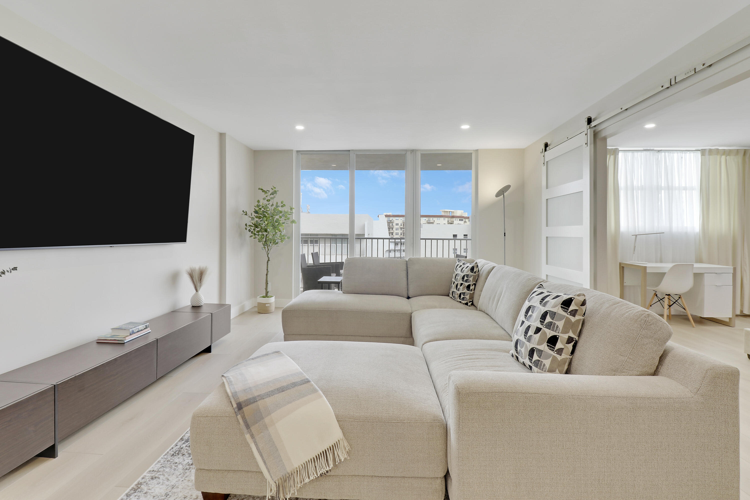 3540 South Ocean Boulevard, Unit 715 South Palm Beach, FL 33480 - Photo 6 of 39 a living room with furniture and a flat screen tv