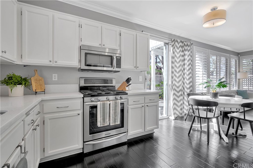 350 Exeter Way Corona, CA 92882 - Photo 50 of 55 a kitchen with stainless steel appliances white cabinets and wooden floors