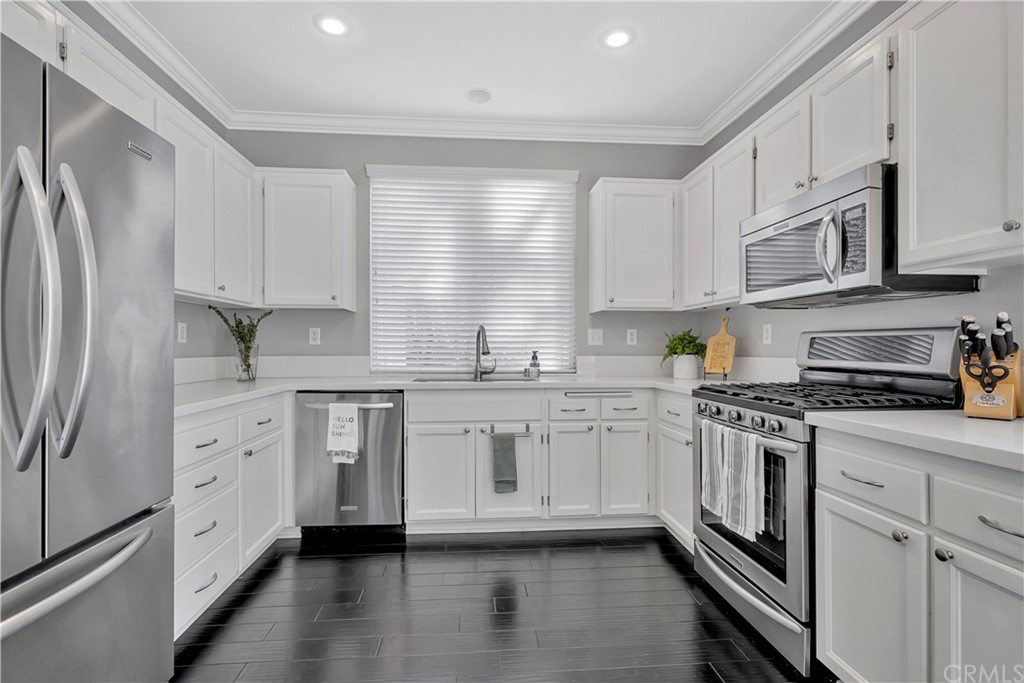 350 Exeter Way Corona, CA 92882 - Photo 9 of 55 a kitchen with stainless steel appliances granite countertop a stove a sink dishwasher a refrigerator white cabinets and wooden floor