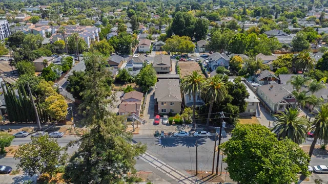 an aerial view of residential houses with outdoor space and trees all around