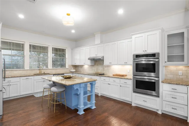 a view of a house with a large tree and wooden fence