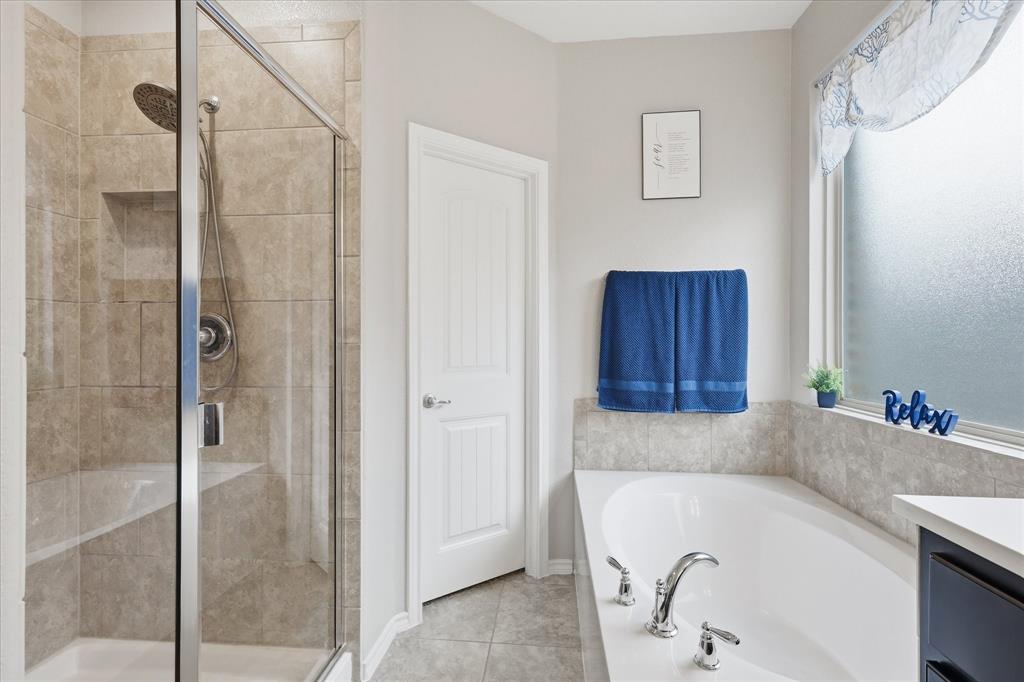 11500 Starlight Ranch Fort Worth, TX 76052 - Photo 22 of 40 Bathroom featuring a spacious built-in tub with chrome fixtures, a separate shower with a glass enclosure and tiled walls, and a window with frosted glass