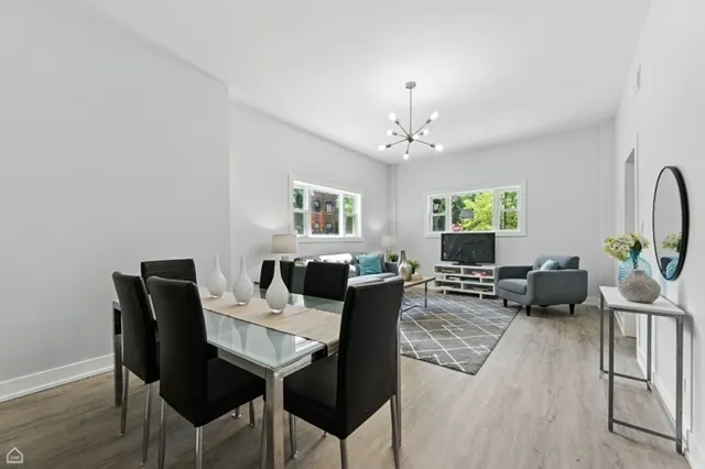 a living room with furniture a chandelier and a dining room