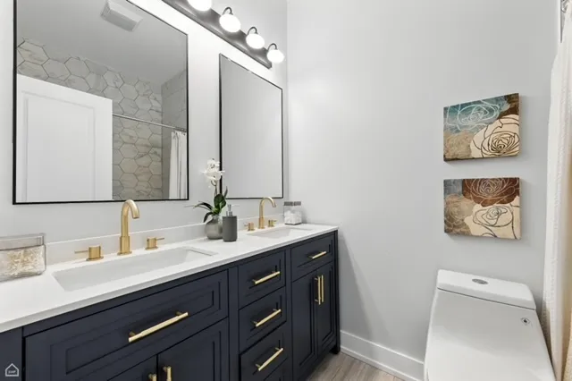 a bathroom with a sink a large mirror and a toilet