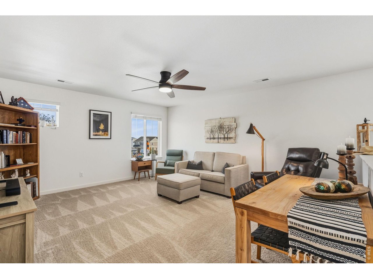 438 Bluebird Road Johnstown, CO 80534 - Photo 17 of 33 Upstairs bonus loft with soft carpeted flooring and ceiling fan; flexible space for media or play.