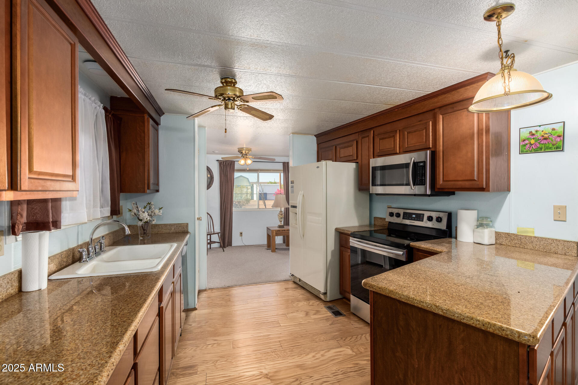 1888 South Goldfield Road Apache Junction, AZ 85119 - Photo 9 of 27 a kitchen with stainless steel appliances granite countertop a sink stove microwave and refrigerator