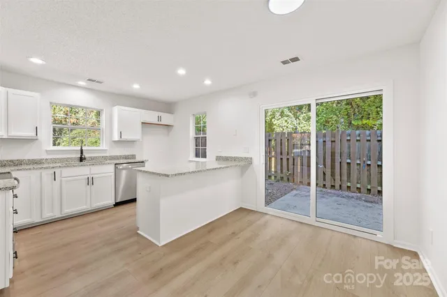 a large white kitchen with a large window