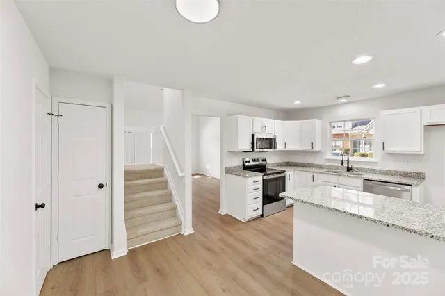 a kitchen with granite countertop a refrigerator and a sink