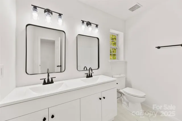 a bathroom with 2 sink and a mirror