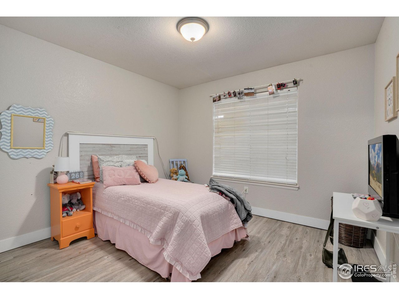 93 Summit View Road Severance, CO 80550 - Photo 13 of 27 a bedroom with a bed and a flat tv screen on the dresser