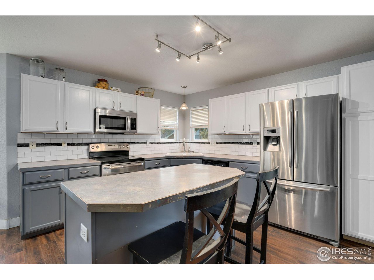 93 Summit View Road Severance, CO 80550 - Photo 7 of 27 a kitchen with kitchen island a refrigerator stove microwave and cabinets