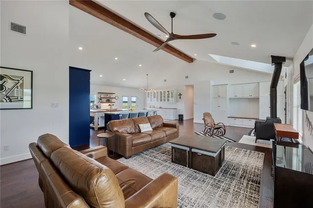 a living room with furniture kitchen view and a chandelier