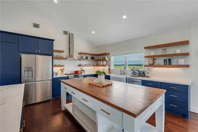 a kitchen with a refrigerator a stove a sink dishwasher and wooden cabinets with wooden floor